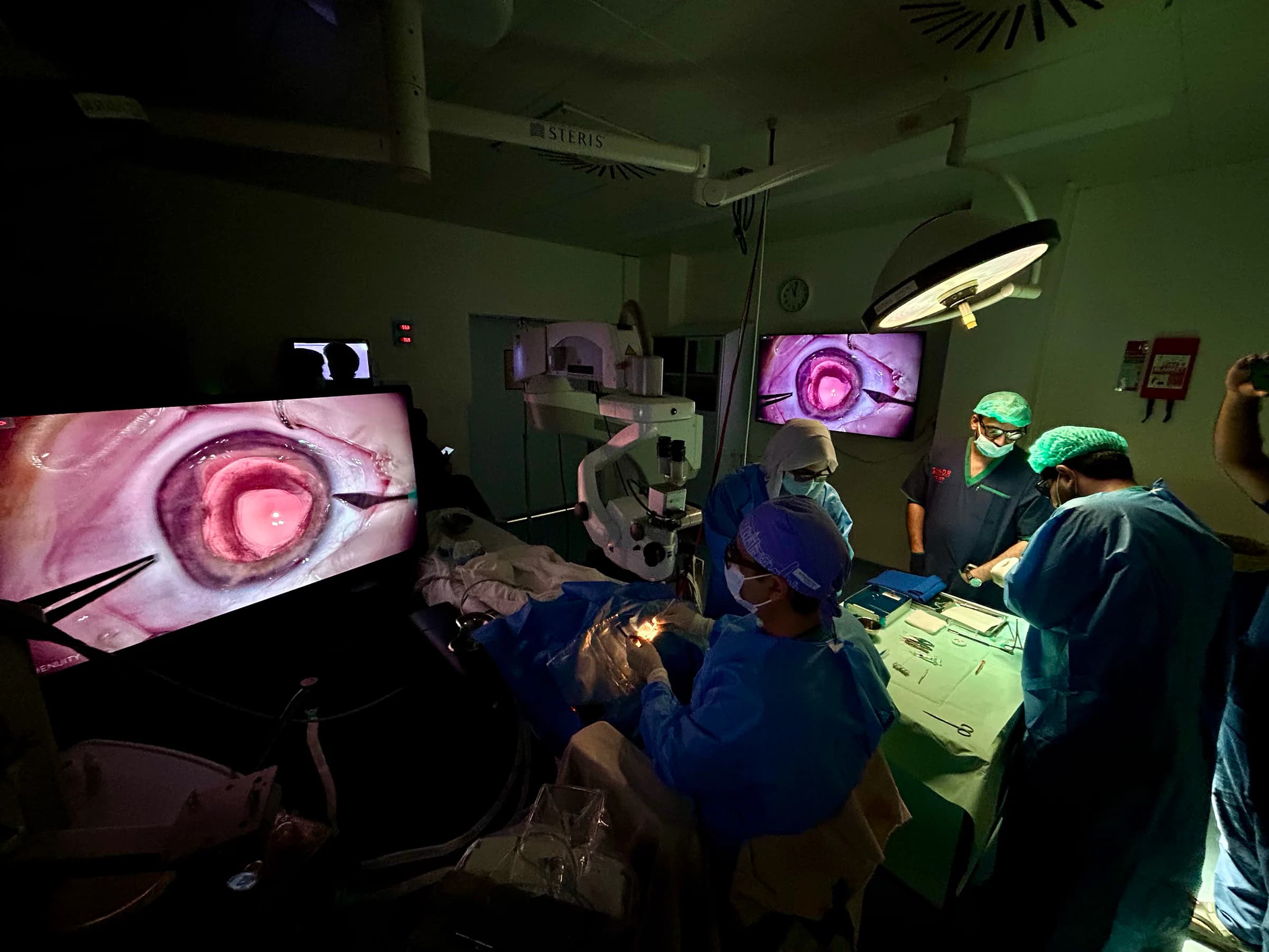 Prof. Dr. Amer Awan performing retinal surgery with two operating displays visible